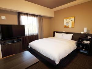 ein Hotelzimmer mit Bett und Flachbildfernseher in der Unterkunft Hotel Route-Inn Shimizu Inter in Shizuoka