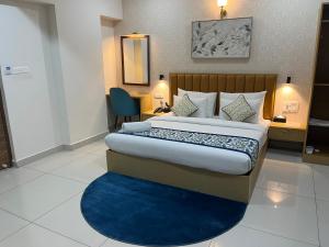a bedroom with a large bed with a blue rug at The Dritan Brookefield ITPL Main Road in Bengaluru