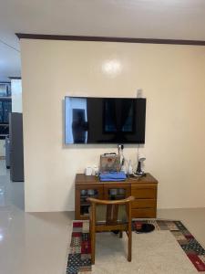 een woonkamer met een tv aan een muur met een stoel bij SMB place 