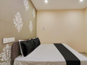 a bedroom with a bed with a black and white pillow at Hotel O BSS INNS in Warangal