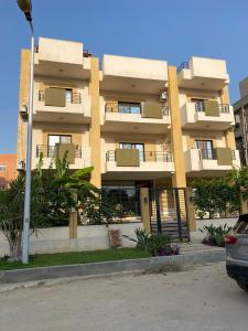 a apartment building with a parking lot in front of it at Travelholic New Cairo Residence in Cairo