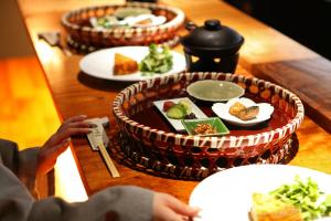 eine Person, die ein Bild von einem Tisch mit Lebensmittelplatten macht in der Unterkunft Umikara in Unzen