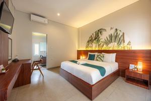 a bedroom with a large bed and a desk at Cove Puspa Canggu in Canggu