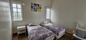 a bedroom with two beds and a table and two windows at B43A1 Silverpark 4th floor Best Mountain view in Bukit Fraser
