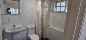 a white bathroom with a toilet and a sink at B43A1 Silverpark 4th floor Best Mountain view in Bukit Fraser