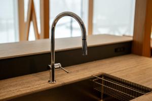 a kitchen sink with a faucet on a counter at Bella Vista Ski Lodge in Nozawa Onsen