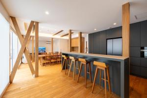a kitchen and dining room with a bar with stools at Bella Vista Ski Lodge in Nozawa Onsen +41 photos