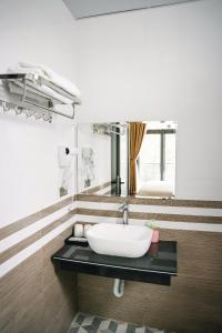 une salle de bains avec un lavabo et un miroir dans l'établissement TAM COC HARBOR VIEW HOTEL, à Ninh Binh
