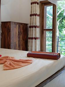 een bed met twee handdoeken en een raam bij Villa Four Seasons in Mirissa