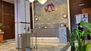 una hall con bancone e orologi appesi al muro di رمادا نيت للشقق المخدومة a Tabuk