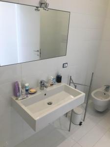a white bathroom with a sink and a toilet at Casa Maria in Salerno