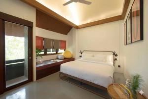 une chambre avec un lit blanc et une fenêtre dans l'établissement Real Rare Resort, à Ban Laem Phak Bia (1)