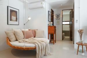 un salon avec un fauteuil en rotin et une couverture dans l'établissement Real Rare Resort, à Ban Laem Phak Bia (1)