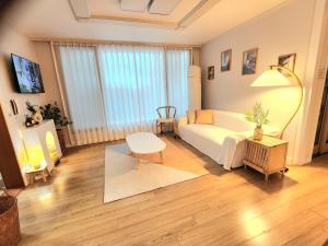 a living room with a white couch and a table at 상무하우스 in Gwangju