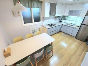 a kitchen with a large white table and chairs at 상무하우스 in Gwangju