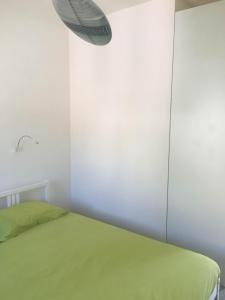 a bedroom with a green bed and a white wall at Casa Maria in Salerno