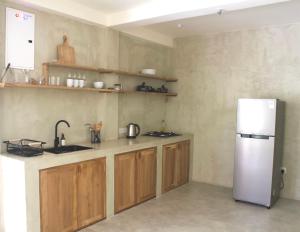 a kitchen with a white refrigerator and wooden cabinets at Dannys Madiha in Kamburugamuwa