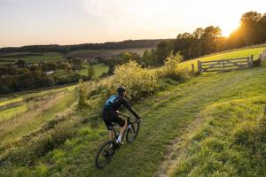 een man die fietst op een grasheuvel bij Het Heideverblijf in Heerlen
