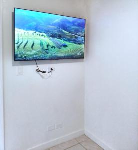 una TV a schermo piatto appesa a una parete di Nadiyah's Escape a Rock Sound