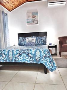 una camera da letto con un letto con un piumone blu e bianco di Nadiyah's Escape a Rock Sound