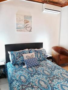 una camera con letto, piumone blu e sedia di Nadiyah's Escape a Rock Sound