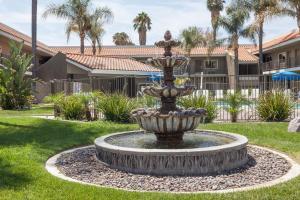 a fountain in a yard in front of a house at Travelodge by Wyndham Hemet CA in Hemet