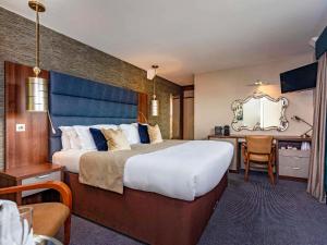 une chambre d'hôtel avec un grand lit et un bureau dans l'établissement Mercure Milton Keynes Hotel, à Milton Keynes 94 autres photos