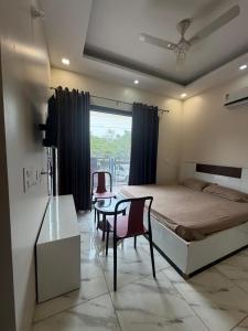 ein Schlafzimmer mit einem Bett, einem Tisch und Stühlen in der Unterkunft Shukla Bhawan in Panchkula