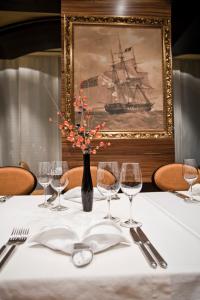 a table with wine glasses and a picture of a ship at Hotel Odissey Jaz in Budva