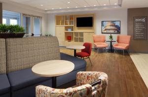 a waiting room with chairs and a couch and tables at Home2 Suites by Hilton Canton in North Canton