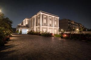 a large white building at night at La Franklin Hotel in Parādīp Garh