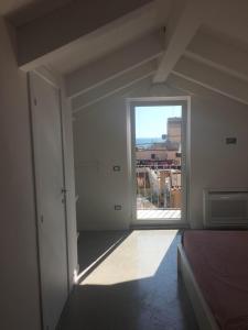 an empty room with a large window and a bed at Casa Maria in Salerno