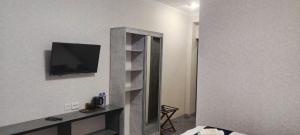 een woonkamer met een tv aan de muur bij Boston Hotel in Yakkasaray +11 foto's