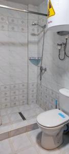 een badkamer met een douche, toilet en wastafel bij Boston Hotel in Yakkasaray