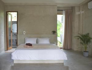 a bedroom with a bed with a woman laying on it at Dannys Madiha in Kamburugamuwa
