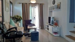 a living room with a couch and a tv at Cosy Preuksa House 120 in Bang Yai