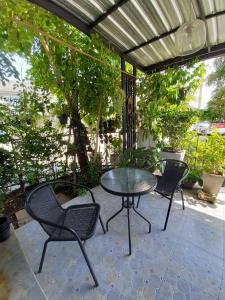 un patio avec une table et des chaises sur un patio dans l'établissement Cosy Preuksa House 120, à Ban Bang Yai