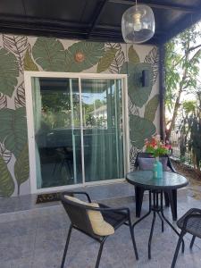 un patio avec une table et des chaises devant un mur dans l'établissement Cosy Preuksa House 120, à Ban Bang Yai