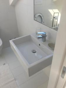 a white bathroom with a sink and a mirror at Casa Maria in Salerno