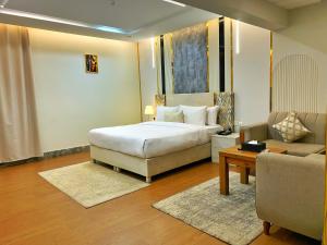 una camera da letto con un letto, una sedia e un divano di رمادا نيت للشقق المخدومة a Tabuk