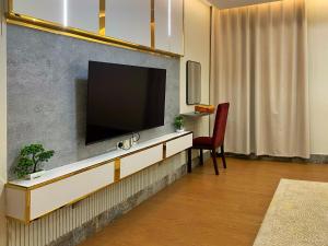 un soggiorno con una TV a schermo piatto su una parete di رمادا نيت للشقق المخدومة a Tabuk Altre 24 foto