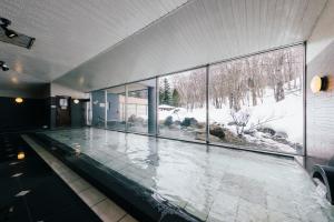 een zwembad in een huis met een groot raam bij Otaru Asari Classe Hotel in Otaru