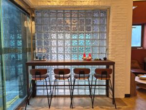 eine Bar mit Hockern vor einem großen Fenster in der Unterkunft H Moment Hotel in Yangsan in Samgong-ni