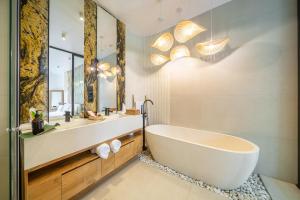 a bathroom with a tub and a large mirror at Ardhana Villas - Luxury Pool Stay with Scenic Views in Ungasan