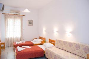 ein Hotelzimmer mit 2 Betten und einem Sofa in der Unterkunft Letta Studios in Apollonia