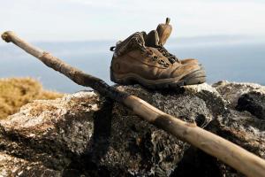 a shoe sitting on top of a rock with a stick at Albergue Monasterio de La Magdalena in Sarria