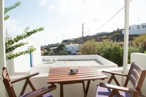 a table and chairs on a balcony with a view of a pool at Letta Studios in Apollonia