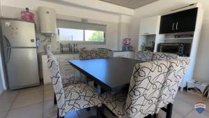 een keuken met een tafel, stoelen en een koelkast bij Homero duplex in Villa Gesell +32 foto's