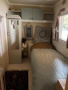 een kleine slaapkamer met een bed en een koelkast bij Het Heideverblijf in Heerlen