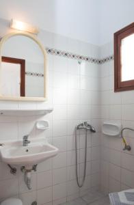 a white bathroom with a sink and a shower at Letta Studios in Apollonia